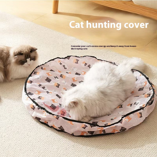 White fluffy cat playing inside round hunting cover hideaway with cat print pattern