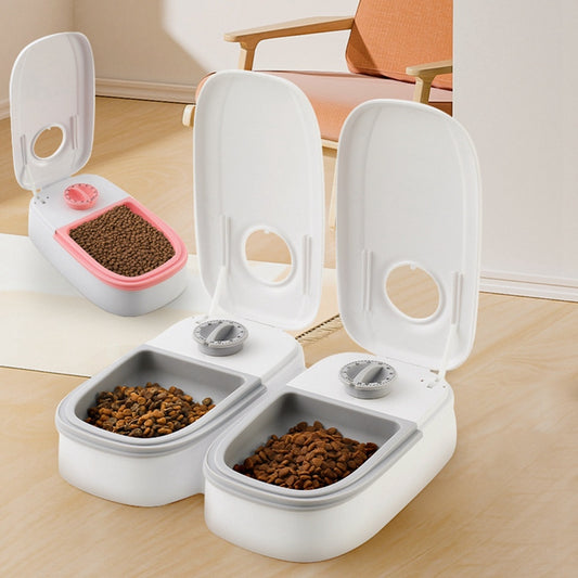 Two automatic cat feeders with open lids, showing food, in a stylish, modern indoor setting.