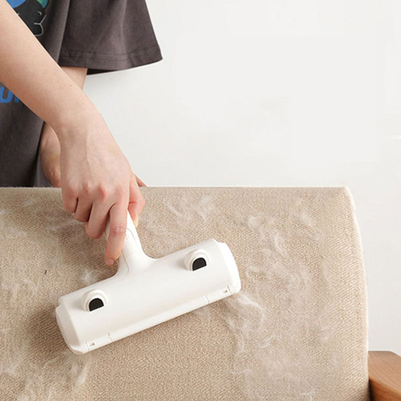 Hand holding a white Pet Lint Roller over a dark carpet, removing pet hair.