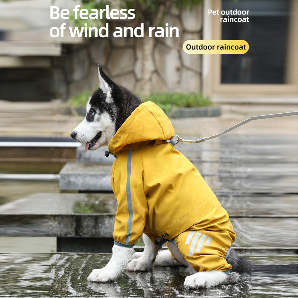 A playful dog in a bright yellow Pet Raincoat sits on wet pavement.