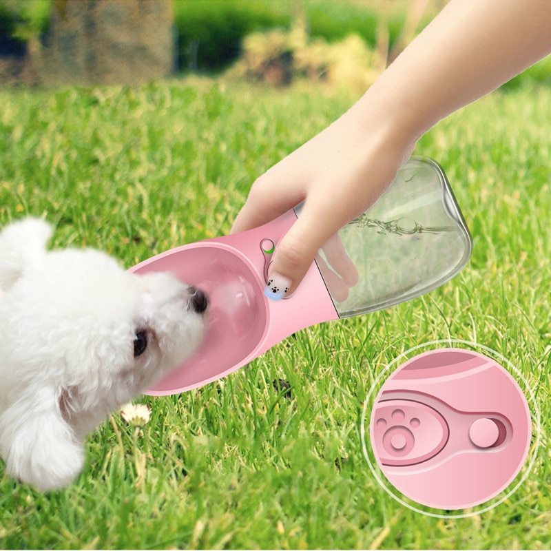 Portable Dog Water Bottle in pink showing a dog drinking from the bowl.